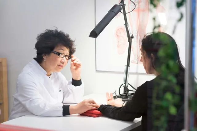 Dr Minqi Yang consulting a patient at the clinic
