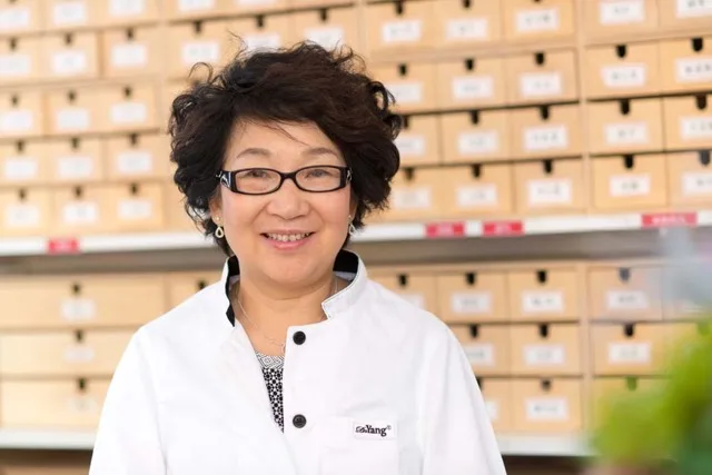 Dr Minqi Yang at the clinic's herbal cabinet