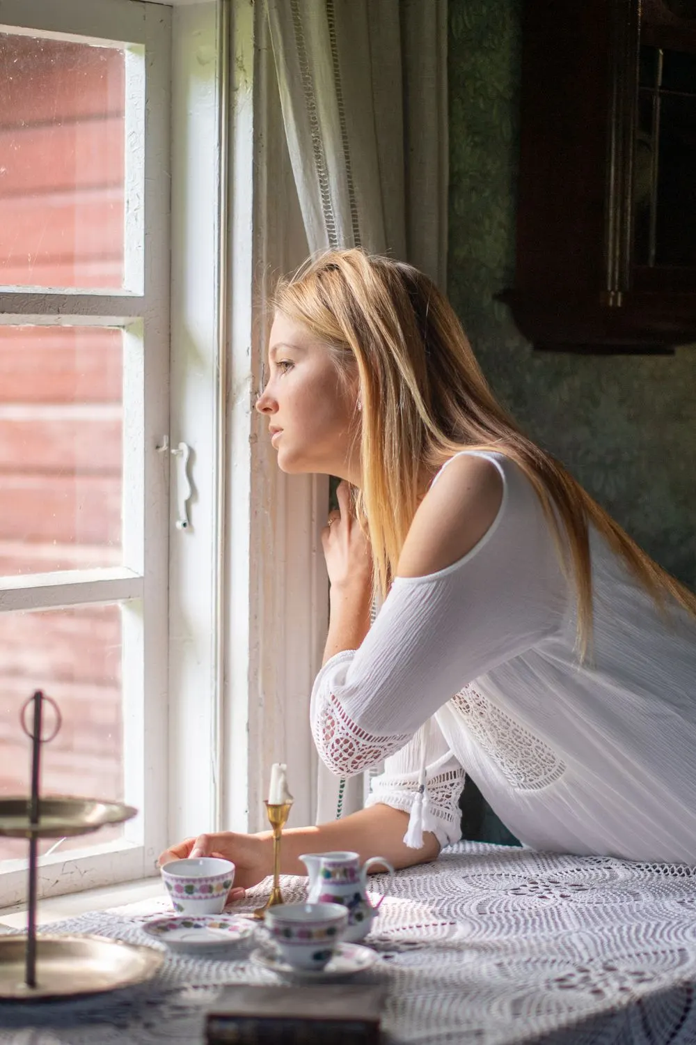 Woman gazing out of a sunlit window